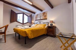 una camera da letto con un grande letto con copriletto giallo di La Corteccia del Faggio ad Abbadia San Salvatore
