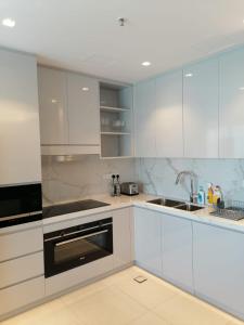 una cocina con armarios blancos y fregadero en Three Bedroom Apartment at Address Residence Fujairah en Sharm