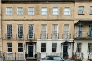 een gebouw waar een auto voor geparkeerd staat bij Stylish Grade II Listed Apartment: The London in Cheltenham