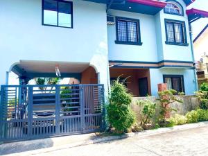 uma casa com um portão azul em frente em Cozy House with Peaceful Vibes em Dinalupihan