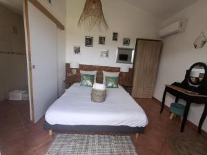 um quarto com uma cama com uma mesa e um espelho em Chambres Isula Bella em Figari