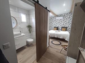 La salle de bains est pourvue d'une chambre avec un lit et un lavabo. dans l'établissement Chambres Isula Bella, à Figari