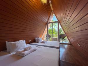 una stanza con due letti e una finestra di La Vie Adventure Trails a Salabusob Altre 105 foto