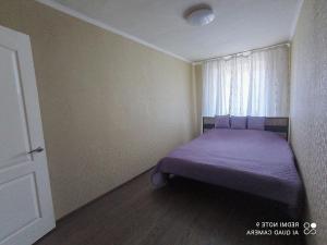 a bedroom with a purple bed with a window at Центр Автовокзал 2 кв Apartaments in Dnipro