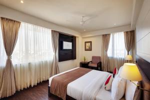 a hotel room with a bed and a window at Whispering Palms Hotel Jaipur in Jaipur