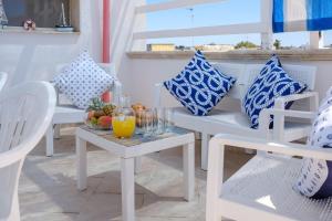 einen Tisch mit einer Schale Obst und einem Glas Orangensaft in der Unterkunft Residenza Acquamarina Vista Mare in Porto Cesareo