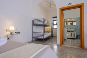 ein Schlafzimmer mit einem Bett und einem Spiegel sowie ein Badezimmer in der Unterkunft Residenza Acquamarina Vista Mare in Porto Cesareo