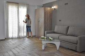a woman standing in a living room looking out the window at Star Studios in Stavros