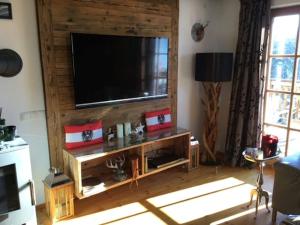 uma sala de estar com televisão numa parede de madeira em Dream Panorama Chalet TOP10 right in the ski em Mittersill