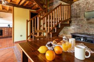 een tafel met een schaal fruit en sinaasappelsap bij Apartamento Rural Celada 2 