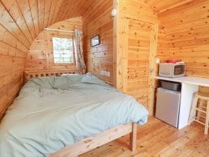ein Schlafzimmer mit einem Bett in einer Holzhütte in der Unterkunft Chestnut 5 in Broadway