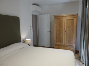 a bedroom with a bed and a wooden cabinet at Ca La Fesola in Palafrugell