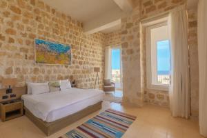 a bedroom with a white bed and a large window at Wadi Sabarah Lodge in Marsa Alam City