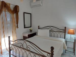 Schlafzimmer mit einem Bett, einem Spiegel und einem Fenster in der Unterkunft Alexandra in Kineta