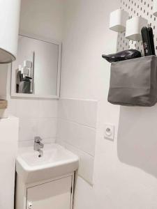 a bathroom with a sink and a bag on the wall at Bonifacio : Studio au coeur de la citadelle in Bonifacio