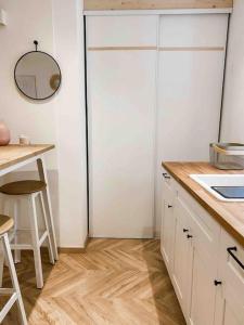 a kitchen with white cabinets and a table and a mirror at Bonifacio : Studio au coeur de la citadelle in Bonifacio