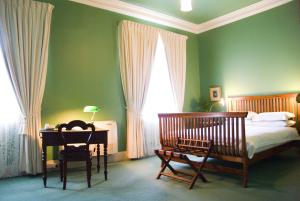 a bedroom with a bed and a desk with a lamp at Imperial Fine Accommodation in Broken Hill