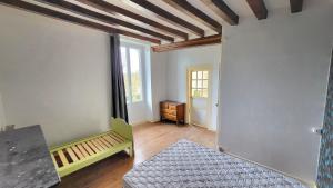 an empty room with a bed and a table at Gite de la Fontaine in La Bazouge-des-Alleux