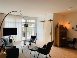 ein Wohnzimmer mit einem Sofa, Stühlen und einem Tisch in der Unterkunft Ferienhaus Sonnenaufgang in Nohfelden