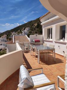 a balcony with a table and chairs on a roof at Vakantiewoning CasaLucka4enjoy private pool and mountain view regio Calpe-Jalon in Jalón