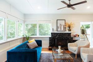 uma sala de estar com um sofá azul e uma lareira em Luxury Treetop Escape with a Garden glasshouse em Kalorama