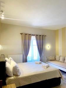 een slaapkamer met een groot bed en een raam bij Hermes Hotel in Mithimna