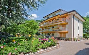un edificio con un jardín de flores delante de él en Villa Sabine - Martha, en Merano