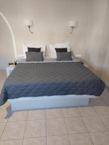 a bed with a blue comforter in a bedroom at Sun Stories Suites in Vóthon