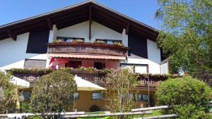 ein Gebäude mit einem Balkon mit Blumen darauf in der Unterkunft Haus Schwärzler - Säntisblick in Sulzberg