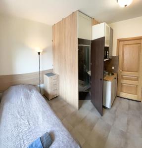 ein kleines Schlafzimmer mit einem Bett und einer Küche in der Unterkunft Klinikų apartamentai in Kaunas