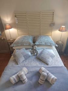 een bed met twee kussens en een teddybeer erop bij Truffle in Sarlat-la-Canéda
