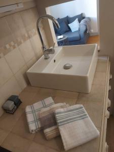 een badkamer met een wastafel en een blauwe bank bij Truffle in Sarlat-la-Canéda