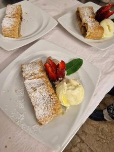 um prato branco com um pedaço de bolo com morangos e gelado em Hotel Venezia Beach em San Mauro a Mare