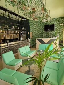 uma sala de espera com cadeiras verdes e um balcão em Hotel Venezia Beach em San Mauro a Mare