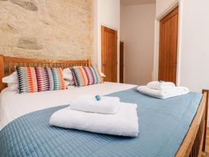 dwa ręczniki siedzą na łóżku w obiekcie Leghorn w mieście St Austell