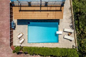an overhead view of a swimming pool with tables and chairs at Villa Rosemarie - Luxurious Villa with Pool Just Steps Away from the Sea By Villa Mana Gers in Psarou