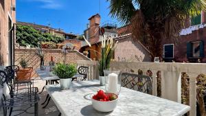 uma mesa com uma tigela de fruta numa varanda em Residence Flowery em Veneza