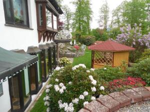 einen Garten mit Blumen und einem Pavillon in der Unterkunft Ferienwohnungen an der Hufeland-Therme in Bad Pyrmont