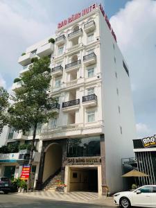 a large white building with a car parked in front of it at SAO BĂNG HOTEL in Thu Dau Mot