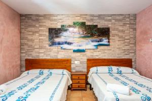 a bedroom with two beds and a painting on the wall at 2 hermanas in Es Pujols