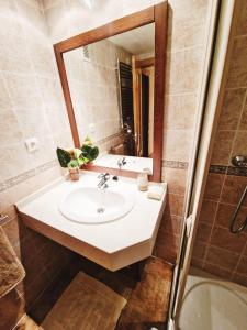 een badkamer met een wastafel, een spiegel en een bad bij Benimar 1 in Cala de Finestrat