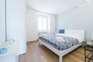 a white bedroom with a bed and a mirror at 105 - La Casa di Jacopo, fronte e vista mare in centro a Riva Trigoso, 20 metri dalla spiaggia in Sestri Levante