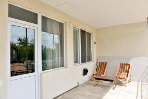 uma porta aberta para um pátio com um banco e uma janela em Surami Guest House - სახლი სურამში em Surami