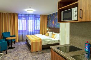 ein Hotelzimmer mit einem Bett und einem TV in der Unterkunft Trip Inn City Hotel Giessen in Gießen