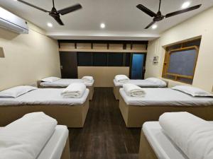 um grupo de quatro camas num quarto em Hotel Padmini International- Sigra em Kakarmatha