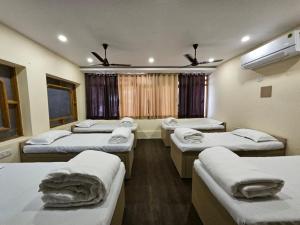 um quarto com quatro camas e uma janela em Hotel Padmini International- Sigra em Kakarmatha