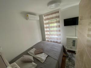 布達佩斯的住宿－Éjjeli Bagoly Étterem és Panzió，一间小卧室,配有一张床和电视