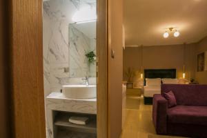 een badkamer met een wastafel en een kamer met een bed bij Marizas luxury suites #1 in Thessaloniki