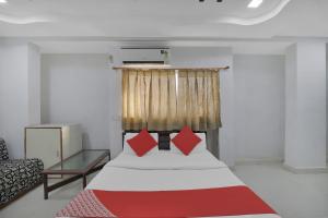 a bedroom with a large bed with red pillows at Hotel O Rudra Palace in Ahmedabad +19 photos