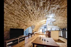 a large living room with a stone wall and a table at Superbe Appartement Rénové - Centre Historique in Montpellier